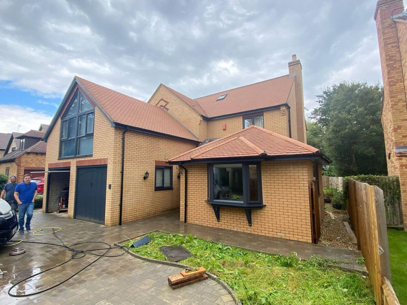 Detached house driveway with pressure washing equipment ready for block paving cleaning in Milton Keynes