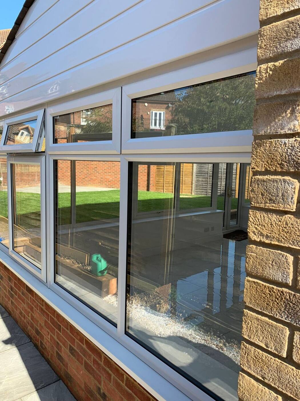 Gleaming conservatory glass panels reflecting garden after professional cleaning in Milton Keynes