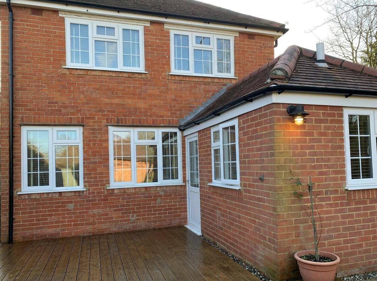 Gutter vacuum pole system clearing gutters on a brick house